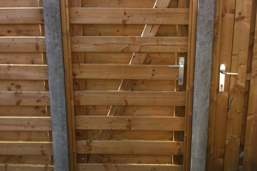 Houten tuinpoort tussen betonpalen